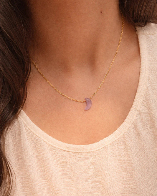 Necklace with a purple pendant worn by a person