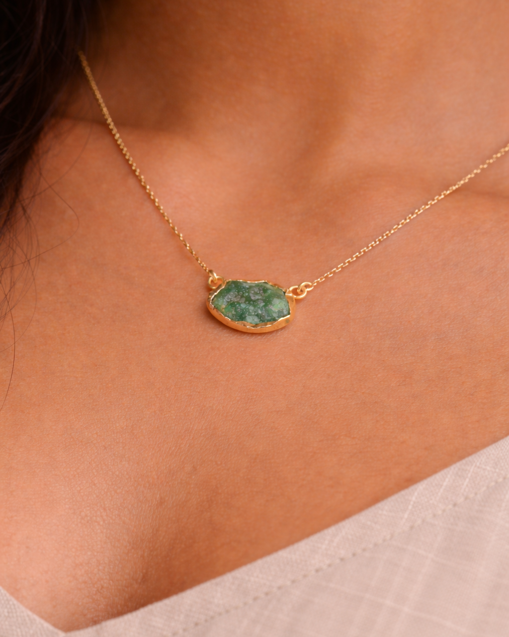 Necklace with a green pendant worn by a person