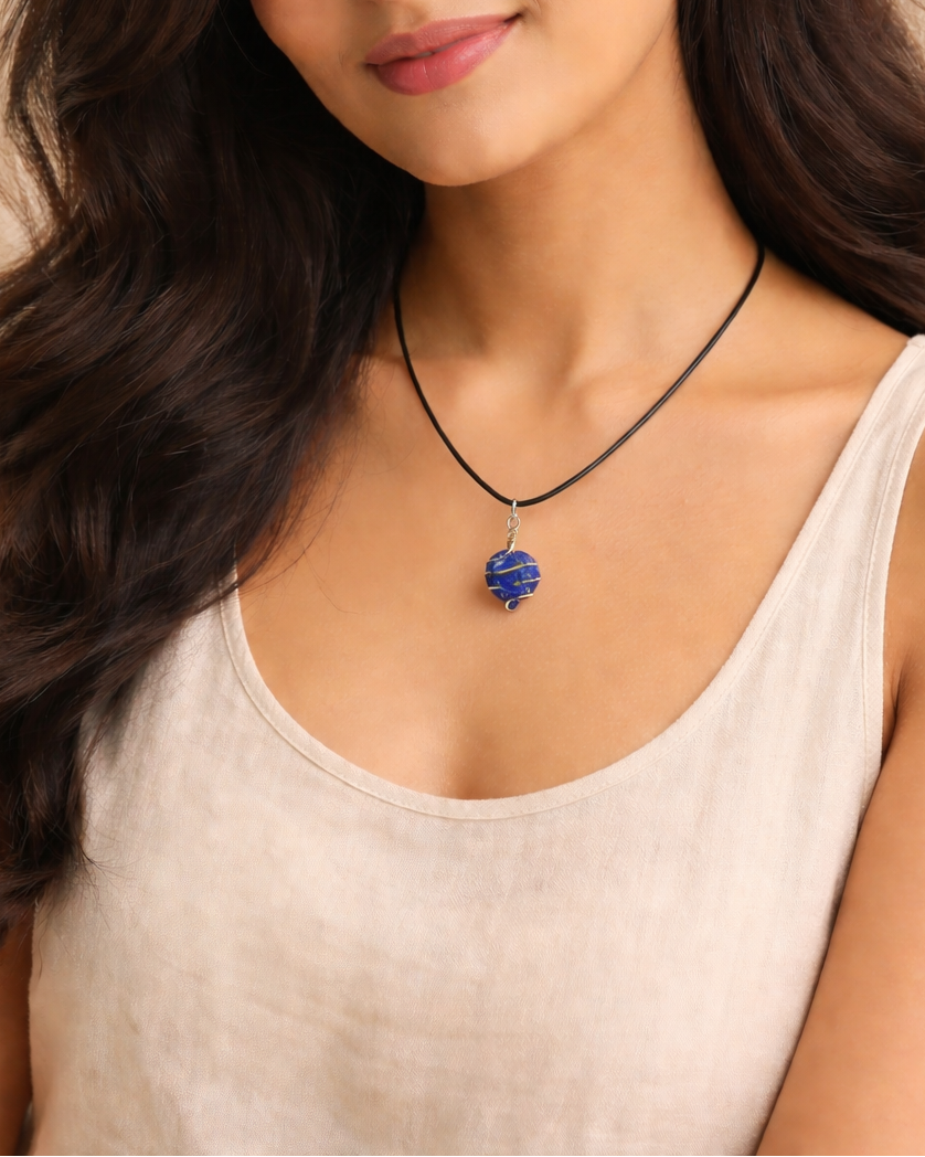 Woman wearing a necklace with a blue pendant against a beige background