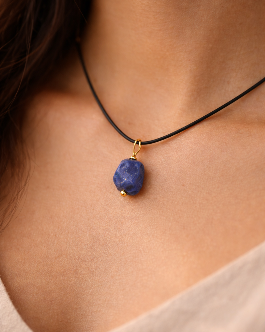 Necklace with a blue pendant on a person's neck