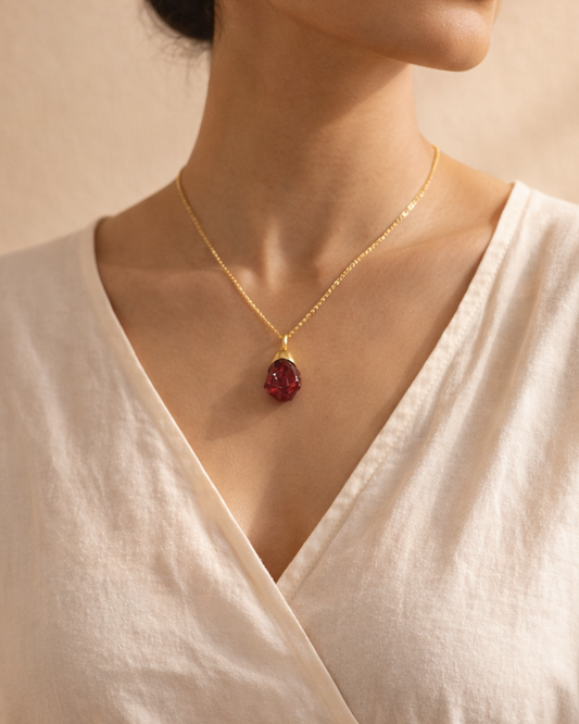 Woman wearing natural garnet pendant with gold plated chain