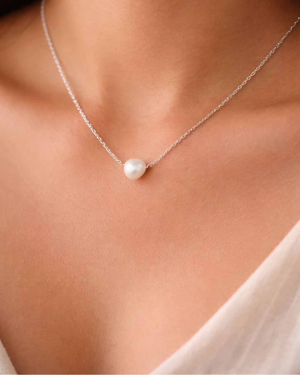 Pearl necklace on a person's neck with a blurred background