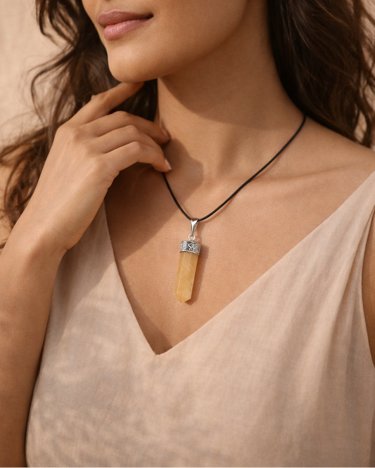 Woman wearing a necklace with a pendant against a beige background