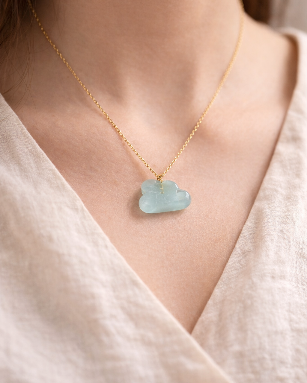 Delicate gold necklace with aquamarine cloud pendant worn on neck, elegant everyday jewelry style