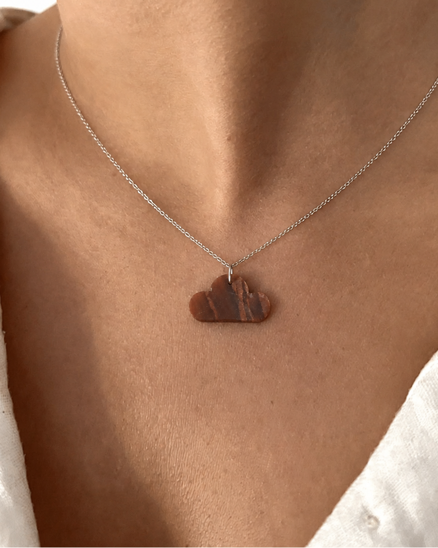 Close-up of natural Tiger Eye cloud pendant necklace on silver chain