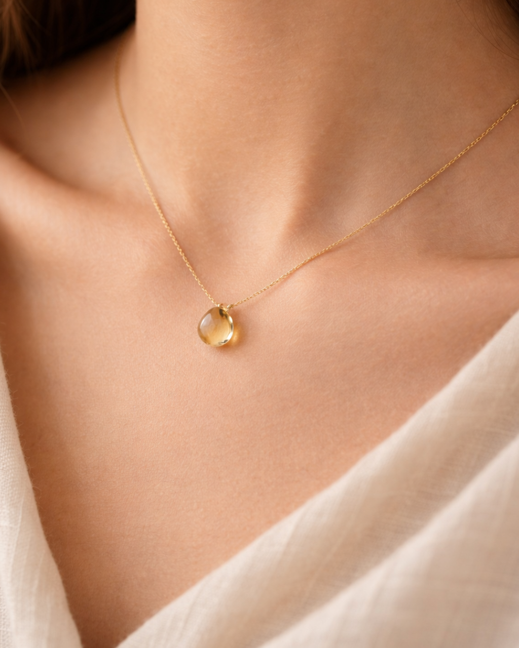 close up of topaz heart pendant on gold chain showing clear luminous stone