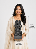 A woman in a cream-colored traditional outfit holds a dark gray stone statue of a Hindu deity. The image includes dimension overlays showing the statue's height as 1.