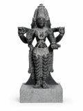 A dark gray stone statue of a four-armed Hindu deity, standing on a square stone base against a plain white background.