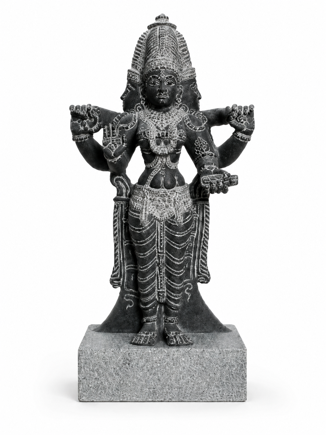 A dark gray stone statue of a four-armed Hindu deity, standing on a square stone base against a plain white background.