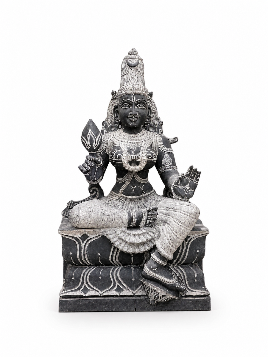 A dark gray and silver stone statue of a seated Hindu deity with ornate carvings, shown against a plain white background.