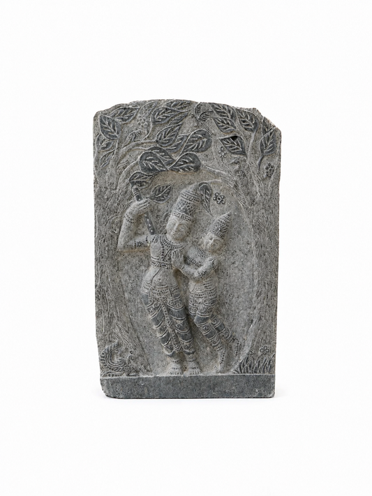 A rectangular gray stone carving featuring a relief sculpture of two dancing figures under a tree, set against a plain white background.