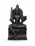 A dark metallic Hindu deity statue seated on a pedestal, holding a sword and an axe, photographed against a plain white background.