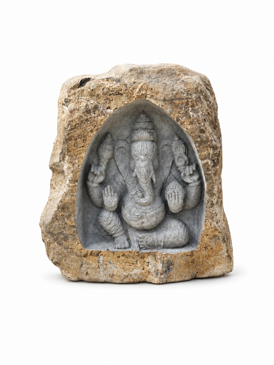 A small carved stone sculpture of Ganesha, set within a rough natural stone frame, photographed against a solid white background.