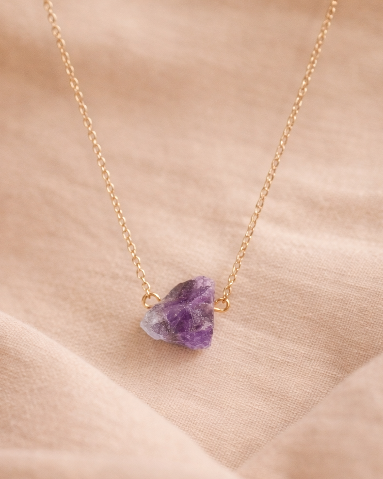 Raw amethyst gold plated necklace on beige aesthetic background