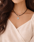 Woman wearing a necklace with a beige background