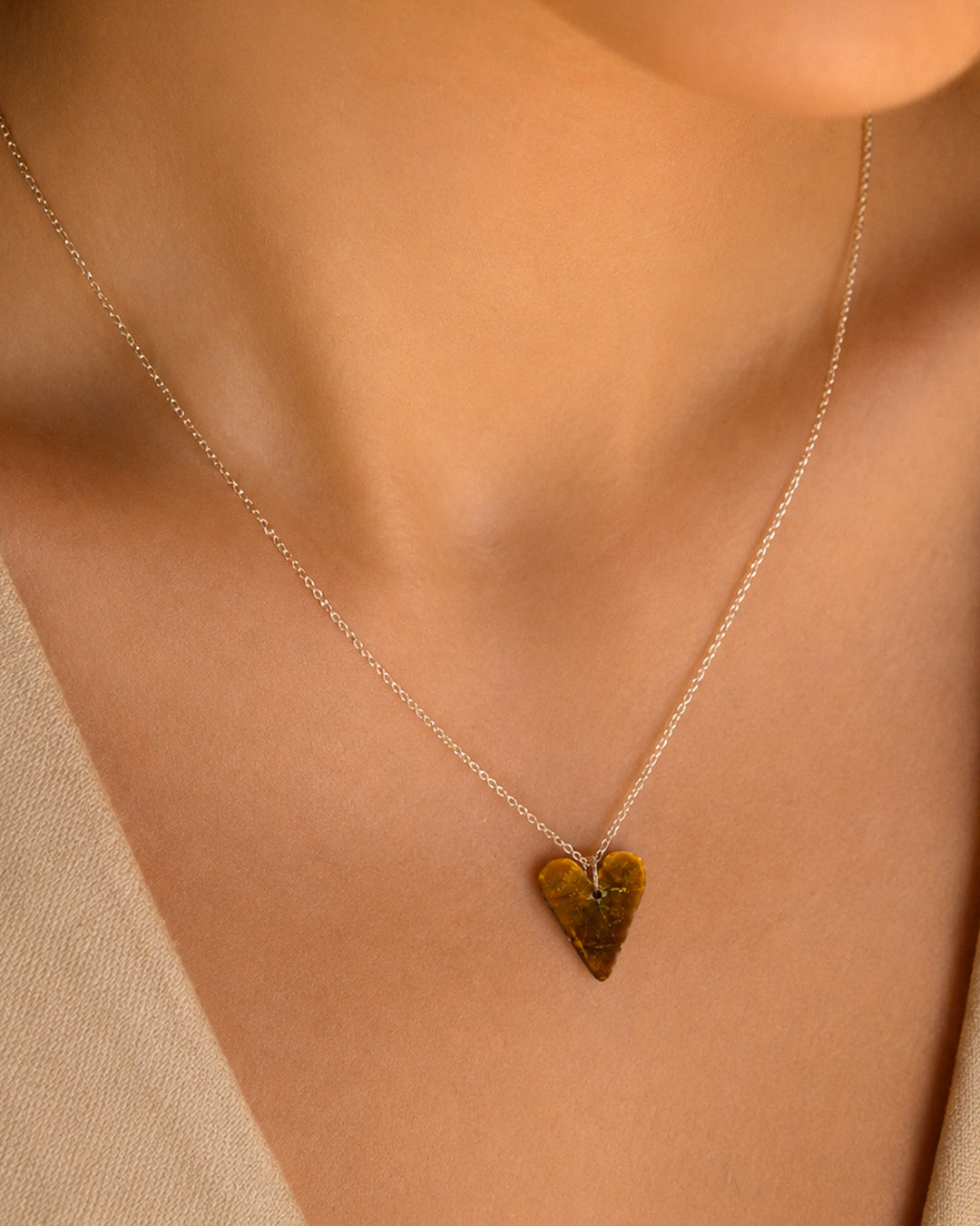 Tiger Eye Heart-shaped pendant necklace on a person with a neutral background