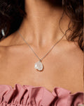 Clear Quartz Necklace with a large, textured pendant worn by a person with pink top