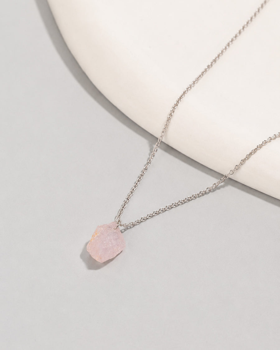 Raw Rose Quartz Necklace with a pink pendant on a light gray background