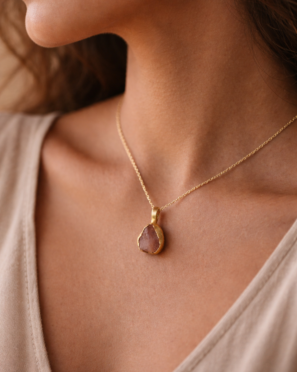 Necklace with a pendant worn by a person, focusing on the jewelry.