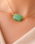 Necklace with a green stone pendant on a person's neck