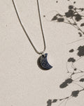 Necklace with a moon-shaped pendant on a light background