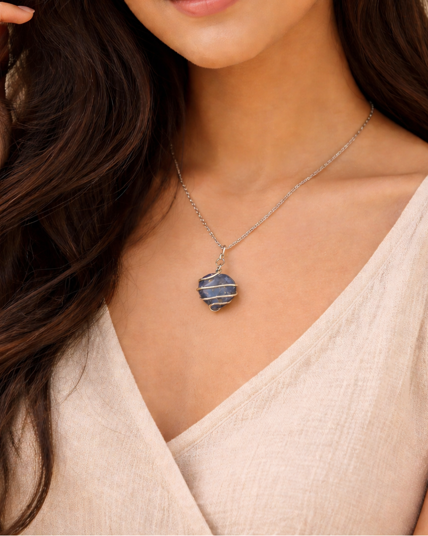 Woman wearing a necklace with a beige top against a neutral background