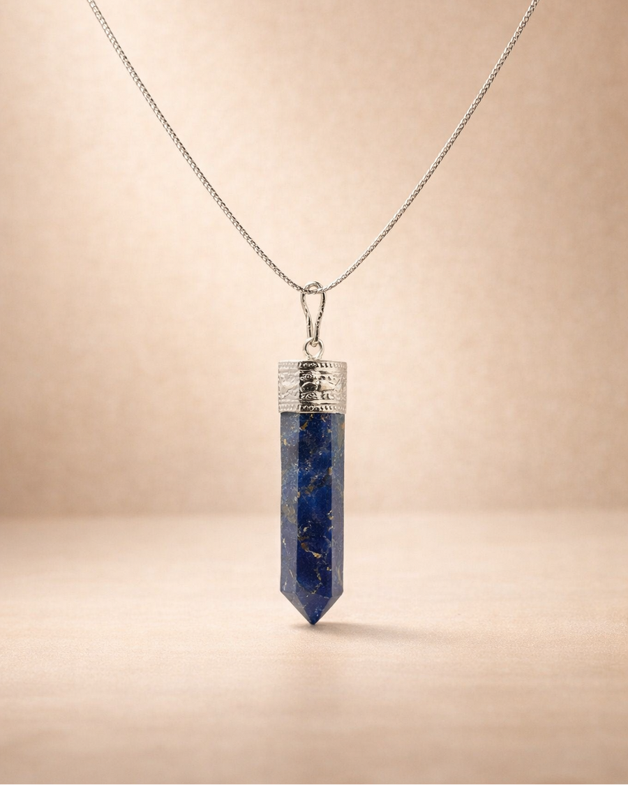 Necklace with a blue crystal pendant on a beige background