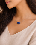 Woman wearing a necklace with a blue pendant