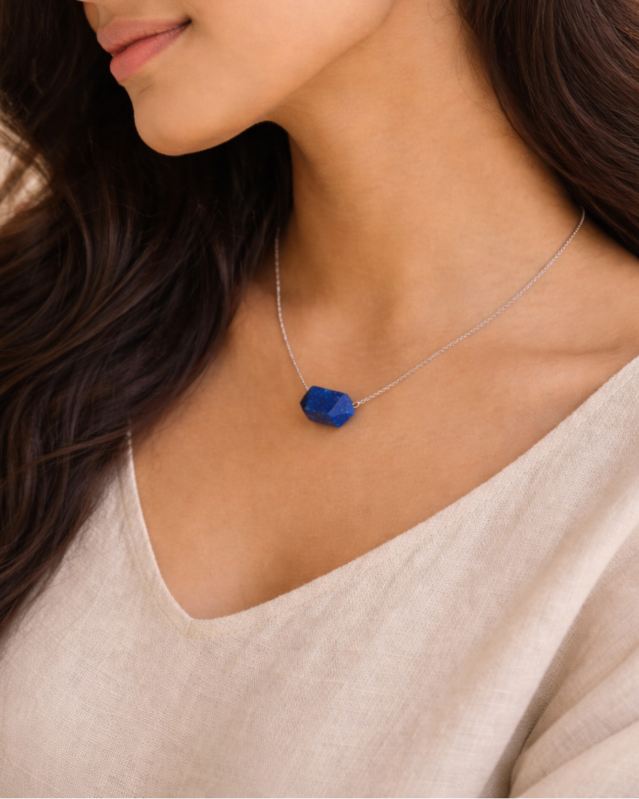 Woman wearing a necklace with a blue pendant