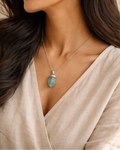 Close-up of blue aquamarine gemstone steel chain pendant