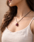 Close-up of raw garnet stone black cord necklace minimal style