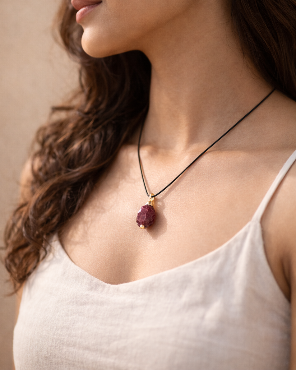 Close-up of raw garnet stone black cord necklace minimal style