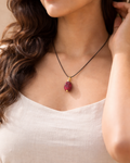 Woman wearing garnet drilled pendant with black cord