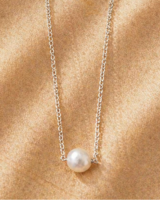 Pearl necklace on a gold fabric background