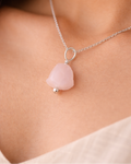 Necklace with a pink pendant on a person's neck