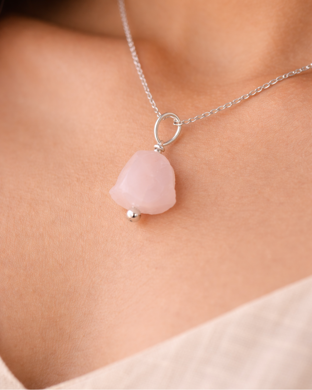 Necklace with a pink pendant on a person's neck