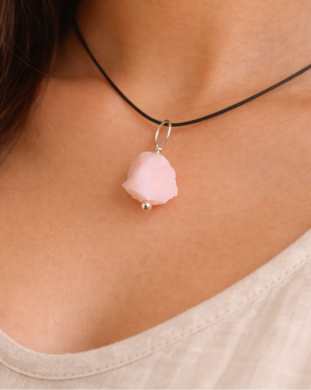 Necklace with a pink pendant worn by a person
