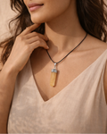Woman wearing a necklace with a pendant against a beige background