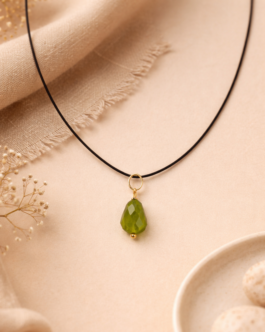 Necklace with a green pendant on a beige fabric background