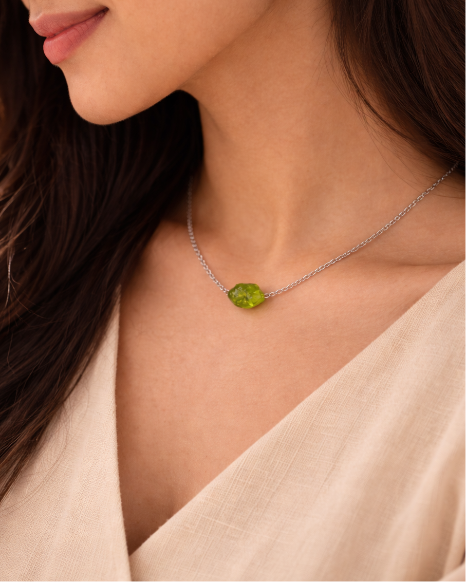 Woman wearing a necklace with a green gemstone