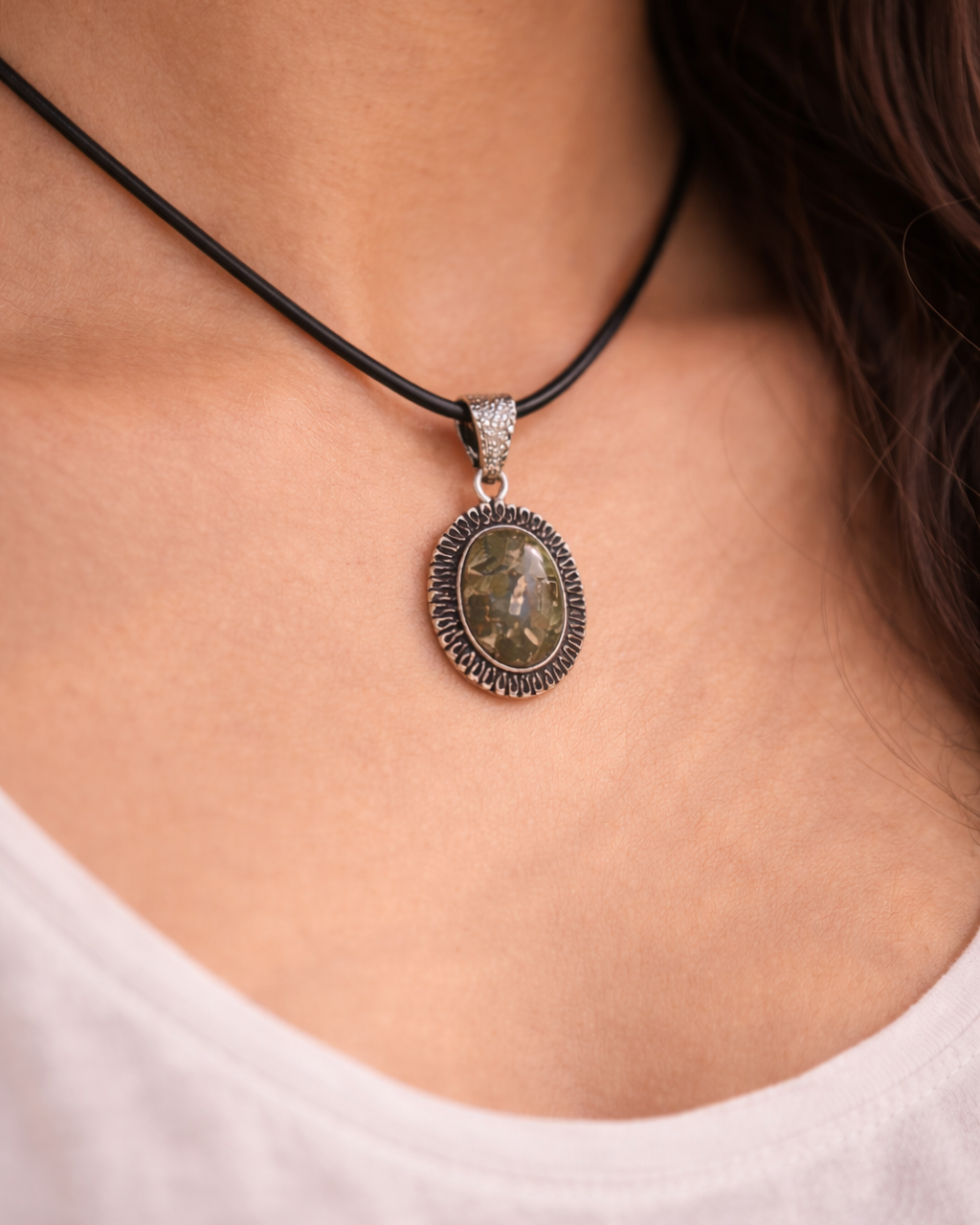 Necklace with a pendant worn by a person, focusing on the jewelry.