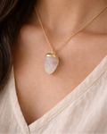 Necklace with a pendant worn by a person, close-up of the necklace on skin.