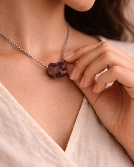 Woman wearing garnet pendant necklace with steel chain