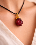 Close-up of deep red garnet stone black cord necklace