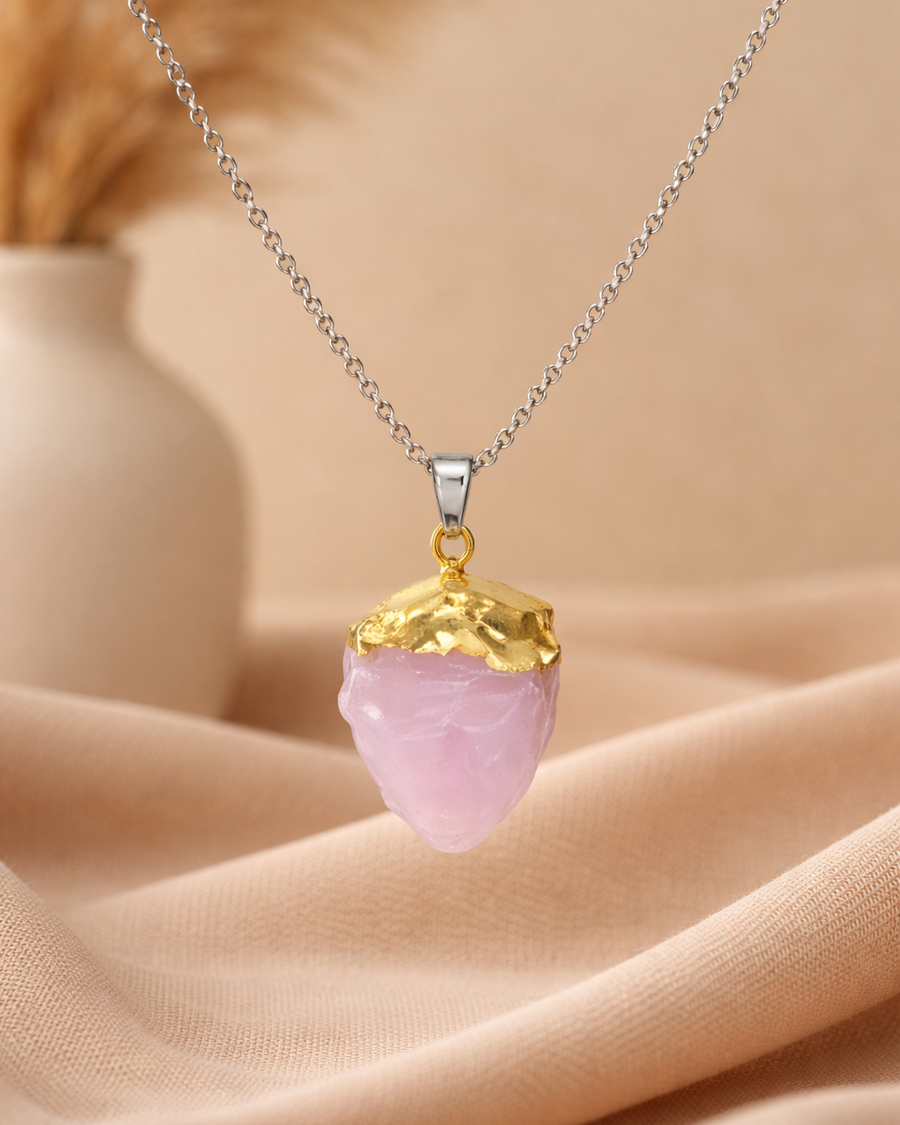 Necklace with a pink crystal pendant on a beige fabric background