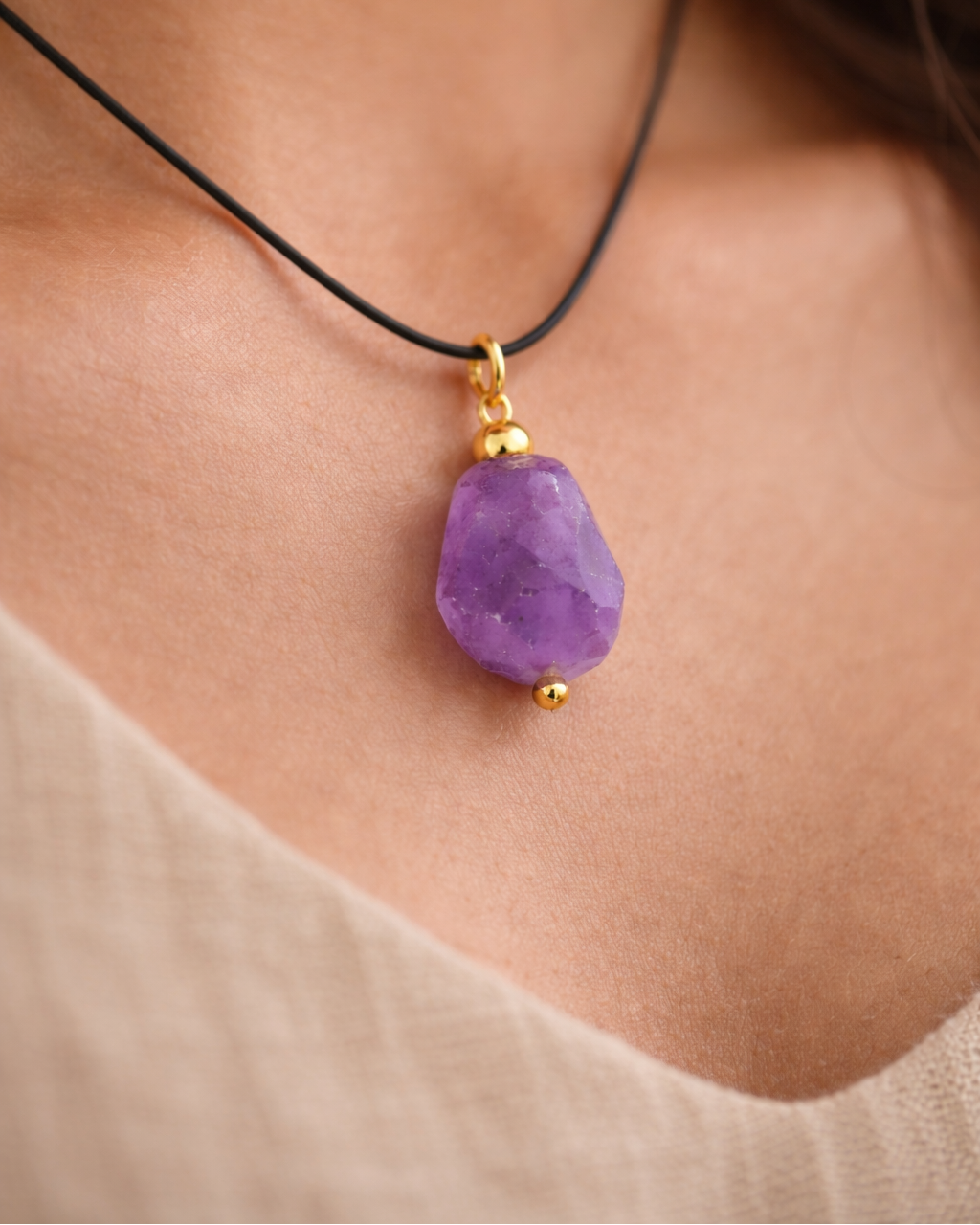 Elegant amethyst pendant on Indian skin tone model black cord