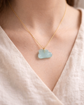 Delicate gold necklace with aquamarine cloud pendant worn on neck, elegant everyday jewelry style