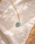 aquamarine heart pendant necklace on gold chain showing light blue natural stone texture
