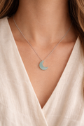 woman wearing aquamarine moon pendant necklace minimal elegant jewelry