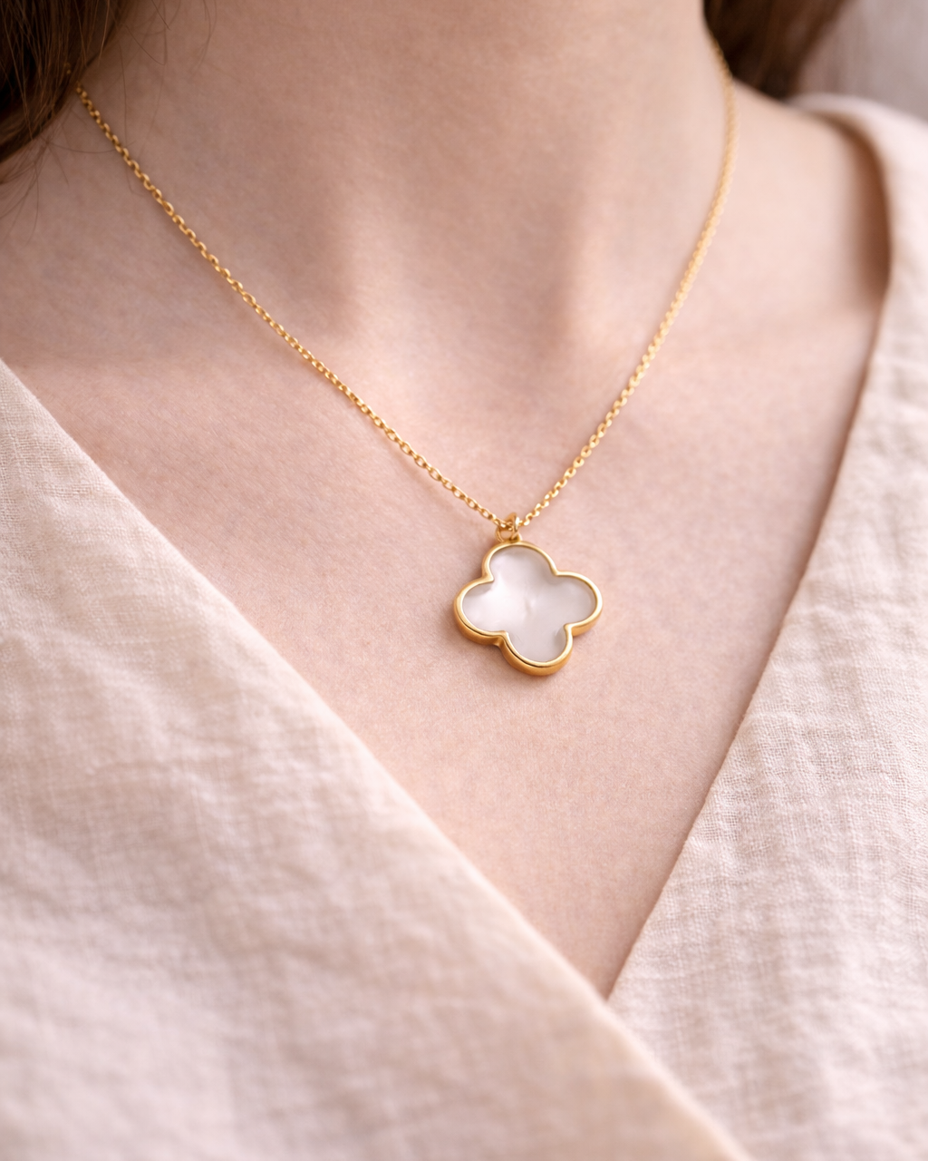 Delicate gold necklace with clear quartz clover pendant worn on neck, elegant everyday gemstone jewelry